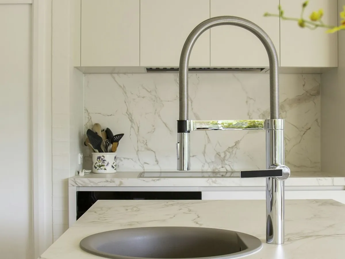 Kitchen island with a pull-down faucet and round sink